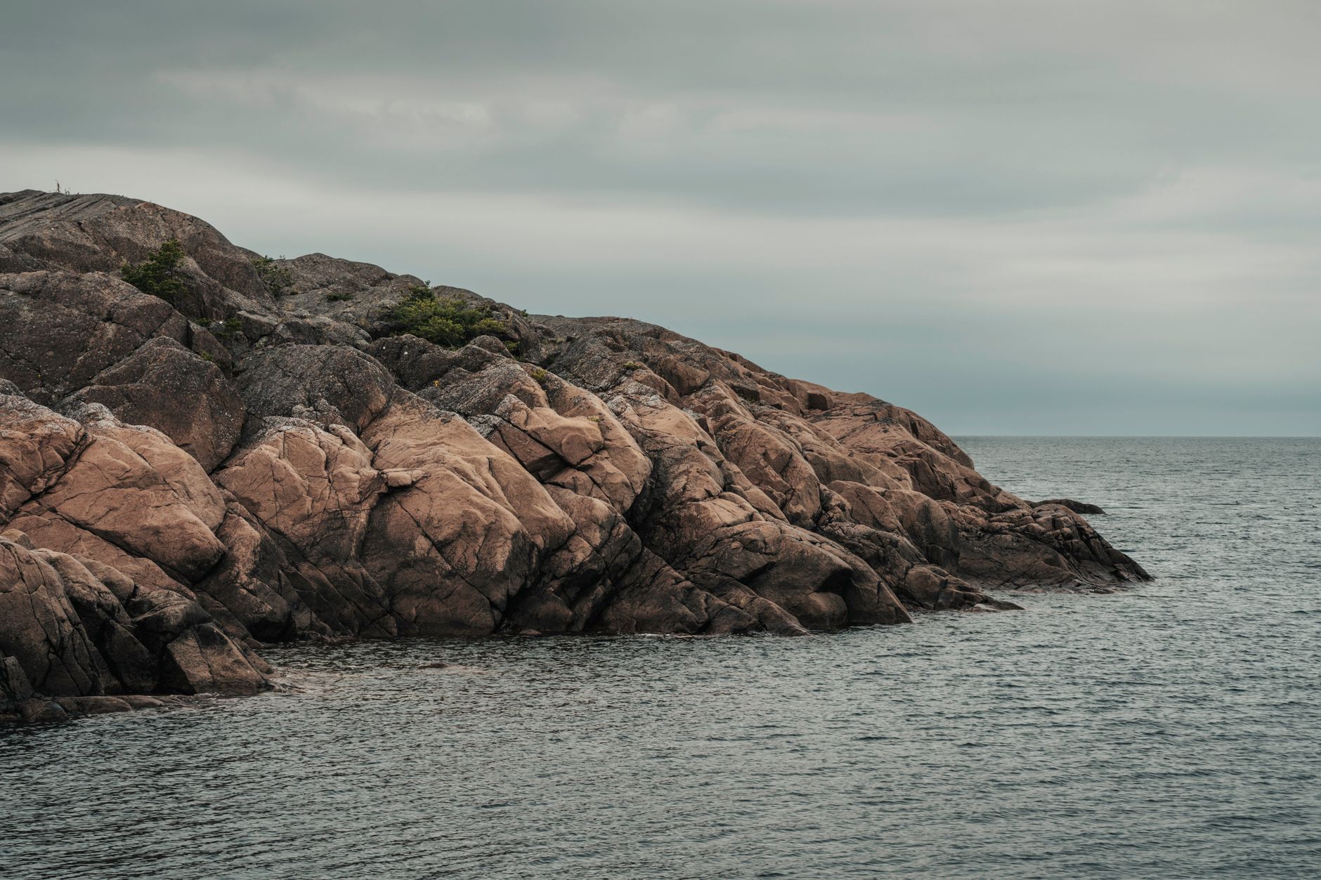 Granitklipper ved havet under en grå himmel
